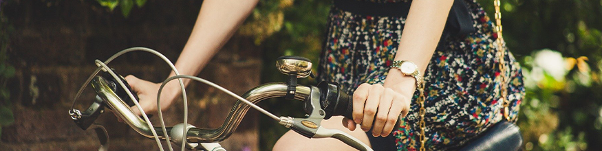 Female riding a bike with hands on handlebars